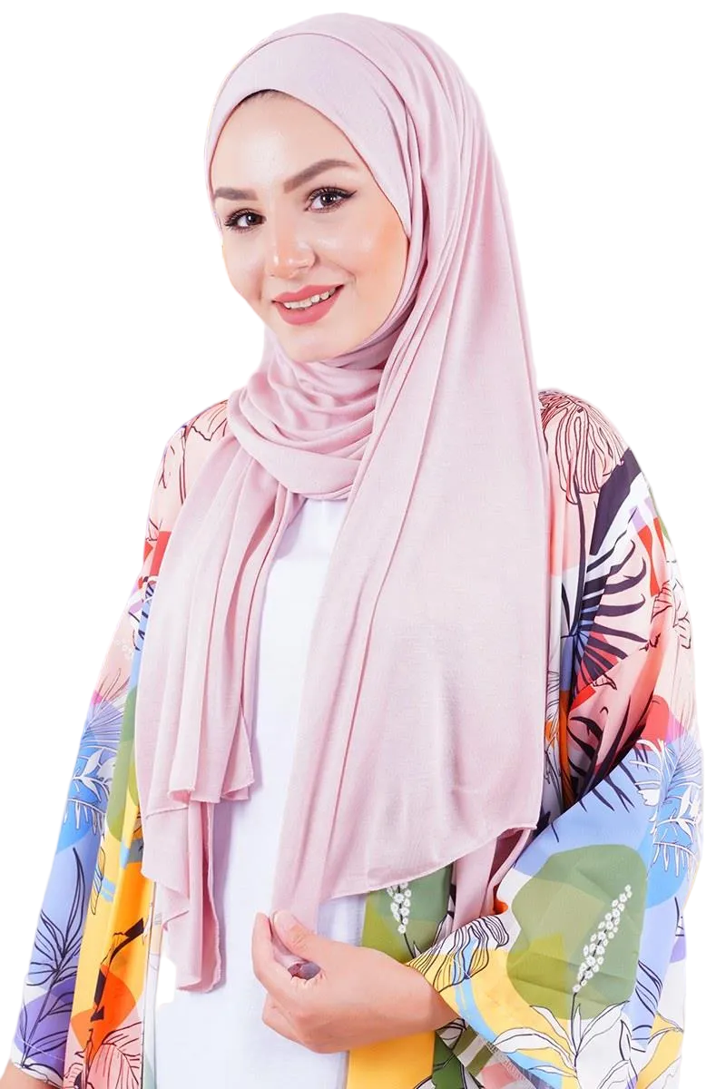 Woman wearing a pink hijab with a colorful floral pattern on a white background
