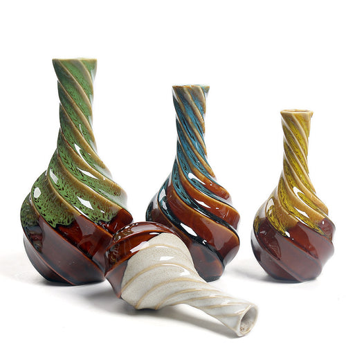 Set of three twisted glass vases with multicolored patterns on a white background