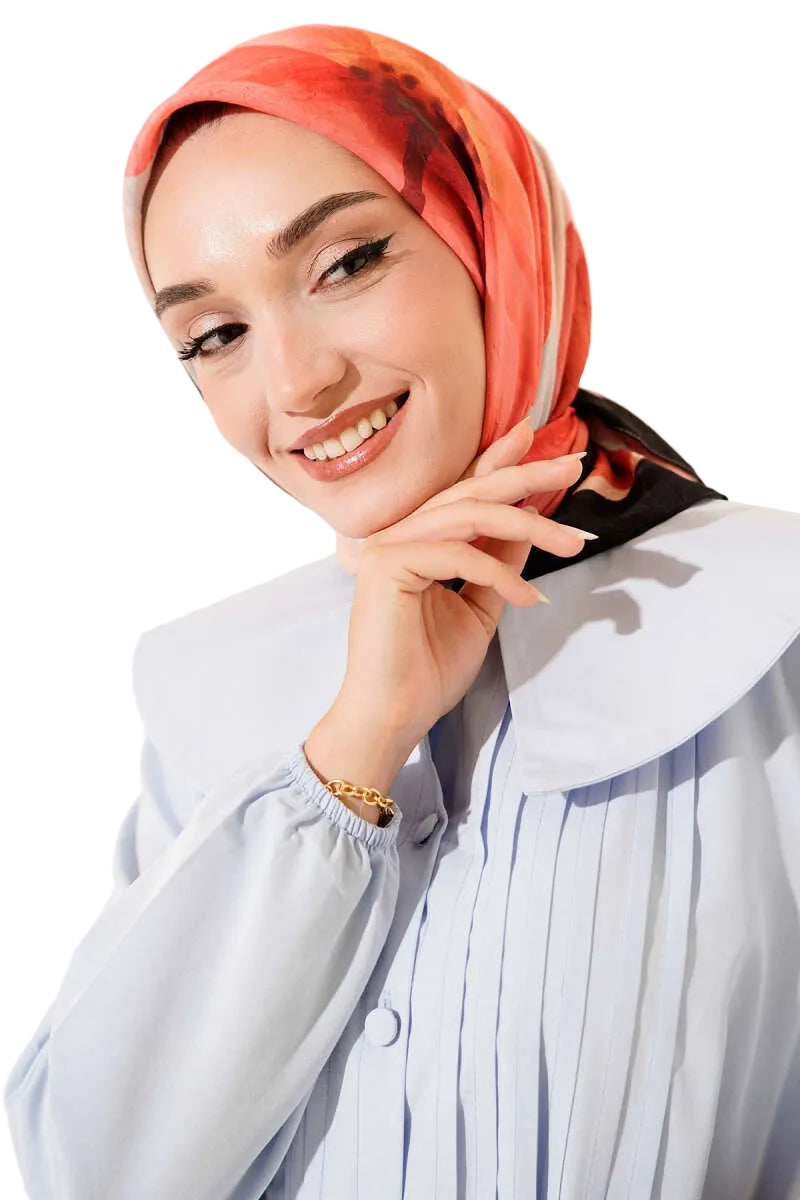 Woman wearing an orange hijab and a light blue shirt against a white background