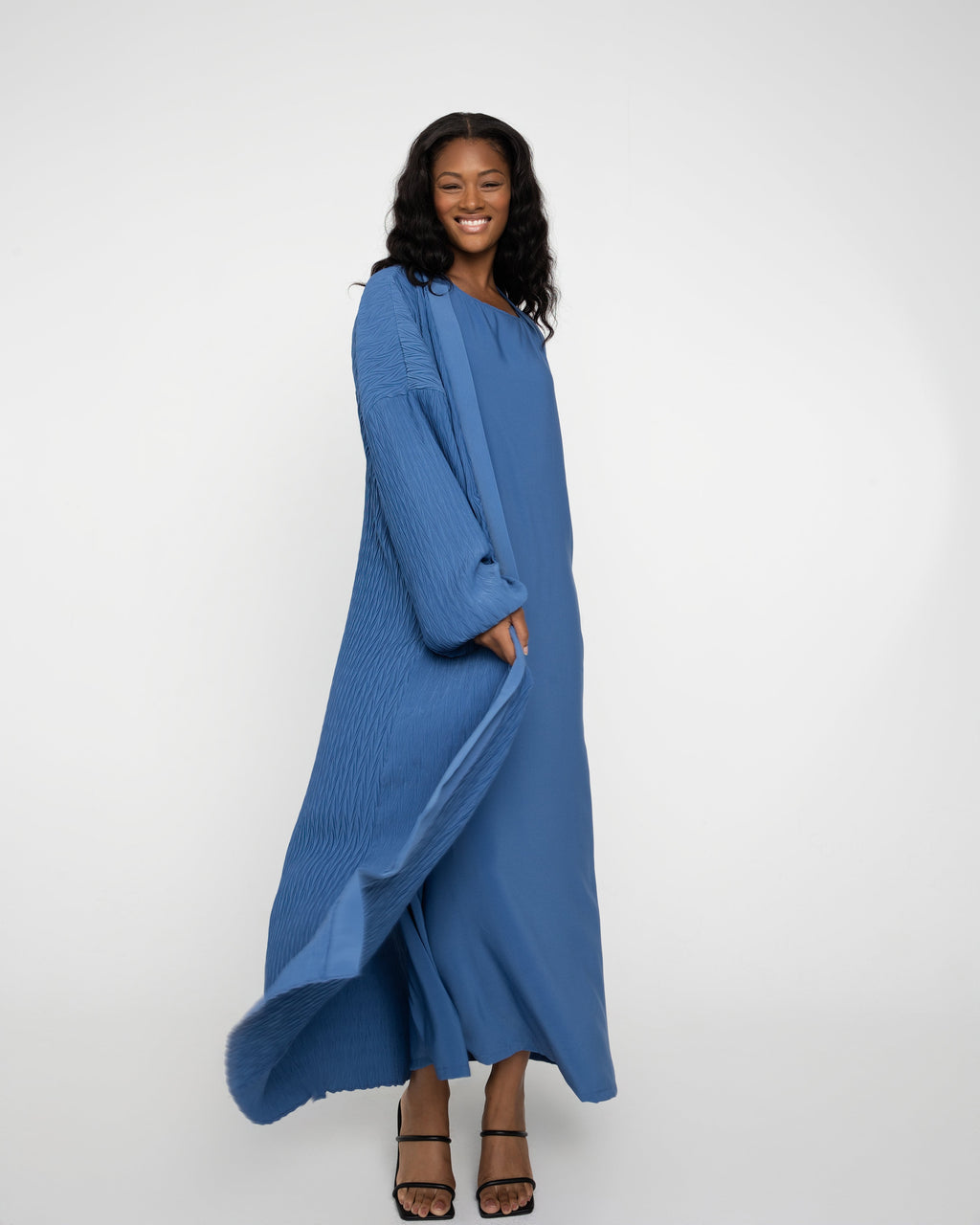 Woman wearing a long blue dress on a white background