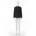 Mannequin wearing a black shirt with white polka dots on a white background