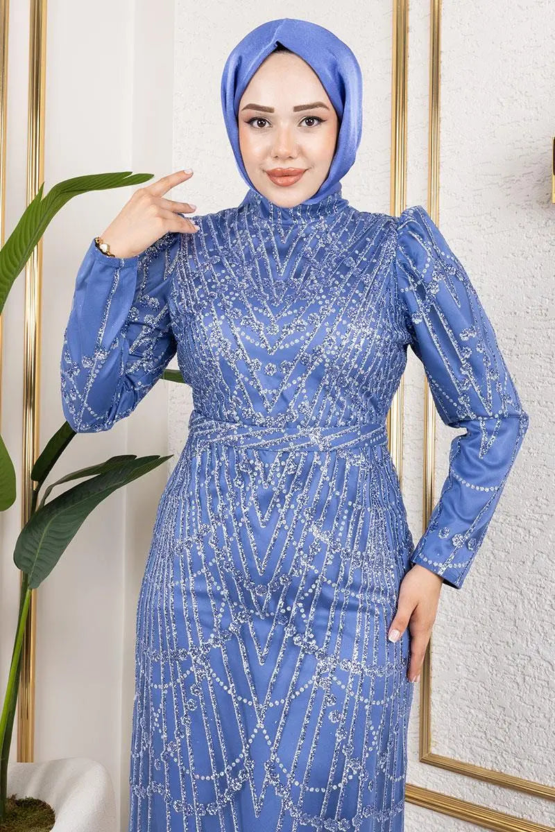 Woman wearing a blue beaded dress and hijab in a well-lit room.