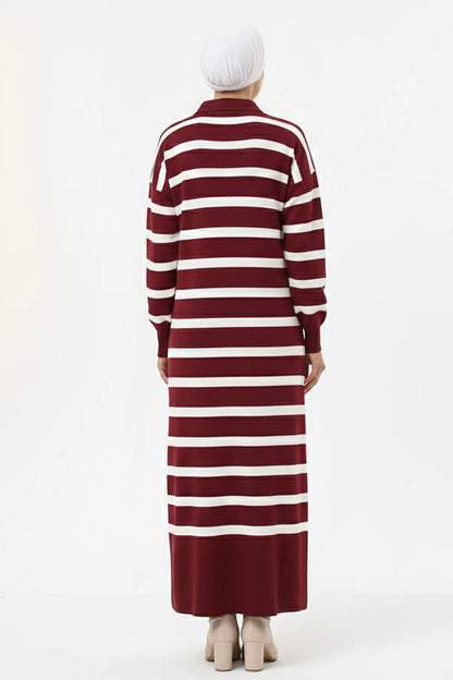 Person wearing a long burgundy and white striped dress on a white background