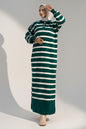Woman wearing a green and white striped dress against a gray background